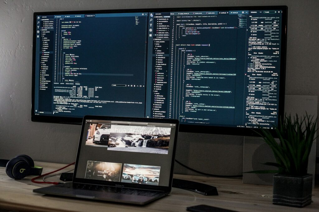 Portátil y monitor con líneas de código sobre un escritorio